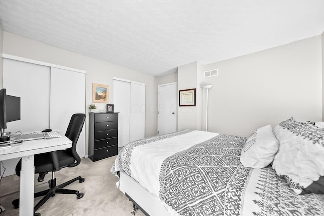 8194 Baltimore Ave Unit 6E, Westerville, OH 43081 - bedroom with multiple closets, light carpet, an office area, and a textured ceiling