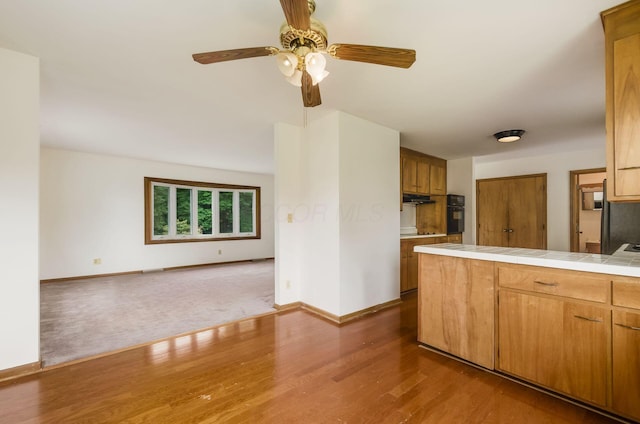 5930 Coonpath Rd NW, Carroll, OH 43112 - kitchen with wood finished floors, tile countertops, a ceiling fan, open floor plan, and under cabinet range hood