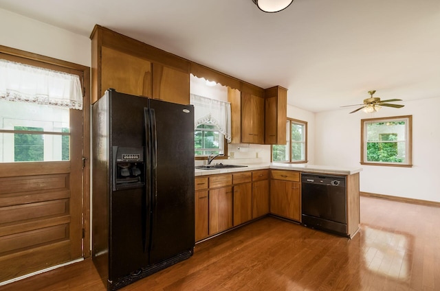 5930 Coonpath Rd NW, Carroll, OH 43112 - kitchen with black appliances, a peninsula, light countertops, dark wood-type flooring, and brown cabinets