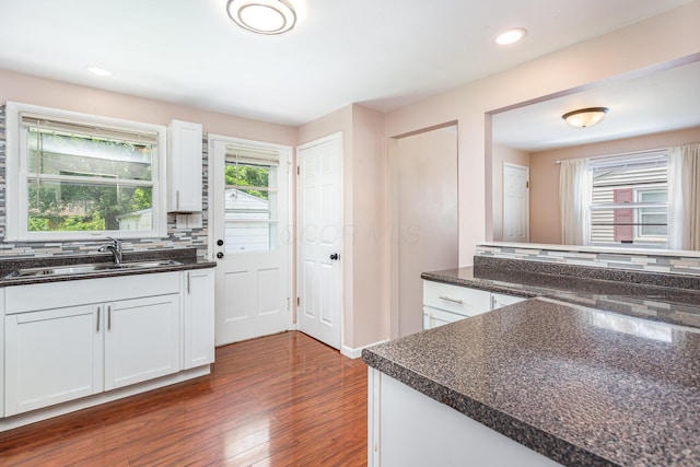 2115 Case Rd, Columbus, OH 43224 - kitchen with dark wood-type flooring, white cabinetry, recessed lighting, decorative backsplash, and dark stone counters