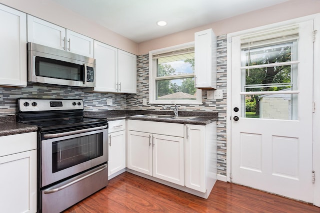 2115 Case Rd, Columbus, OH 43224 - kitchen with appliances with stainless steel finishes, dark countertops, dark wood-type flooring, white cabinetry, and recessed lighting