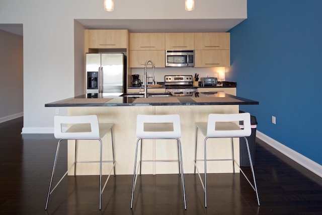 100 E Gay St Unit 804, Columbus, OH 43215 - kitchen with appliances with stainless steel finishes, light brown cabinets, dark wood-type flooring, and dark countertops