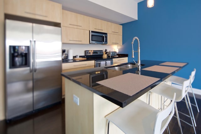 100 E Gay St Unit 804, Columbus, OH 43215 - kitchen featuring stainless steel appliances, light brown cabinetry, a breakfast bar area, dark countertops, and modern cabinets