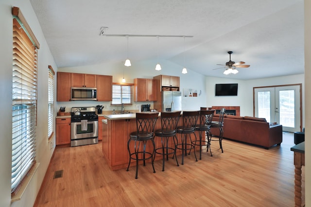 3808 Peak Ridge Dr, Columbus, OH 43230 - kitchen featuring appliances with stainless steel finishes, vaulted ceiling, light wood-type flooring, a breakfast bar, and open floor plan