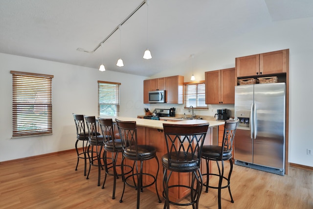 3808 Peak Ridge Dr, Columbus, OH 43230 - kitchen featuring appliances with stainless steel finishes, light wood-type flooring, a kitchen breakfast bar, and lofted ceiling