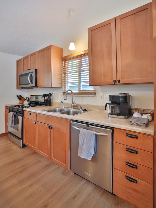 3808 Peak Ridge Dr, Columbus, OH 43230 - kitchen featuring stainless steel appliances, light wood finished floors, light countertops, and hanging light fixtures