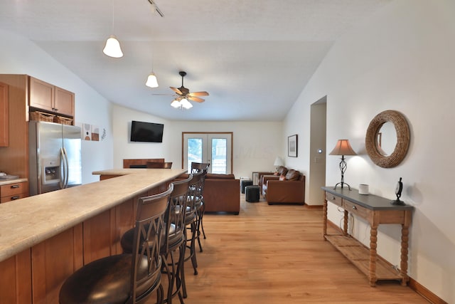 3808 Peak Ridge Dr, Columbus, OH 43230 - kitchen with stainless steel refrigerator with ice dispenser, vaulted ceiling, open floor plan, a breakfast bar area, and light wood-style floors