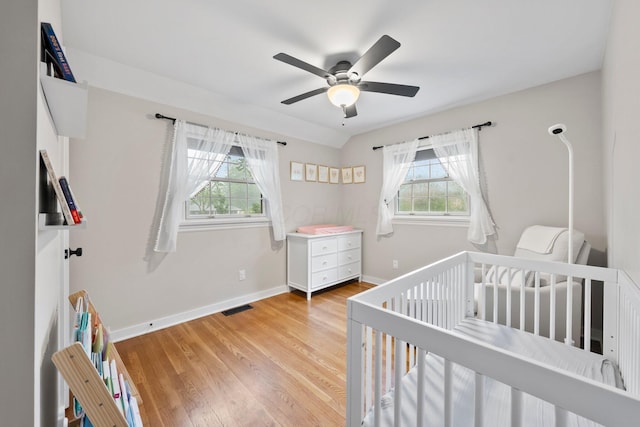 2560 Zollinger Rd, Columbus, OH 43221 - bedroom with a nursery area, light wood-style floors, and ceiling fan