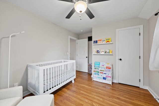 2560 Zollinger Rd, Columbus, OH 43221 - bedroom with light wood-style floors, a crib, and ceiling fan