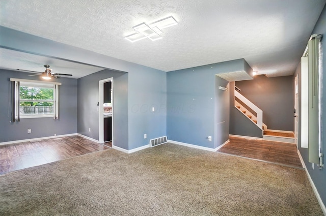 2605 Bella Via Ave, Columbus, OH 43231 - unfurnished living room with carpet, stairs, a ceiling fan, a textured ceiling, and wood finished floors