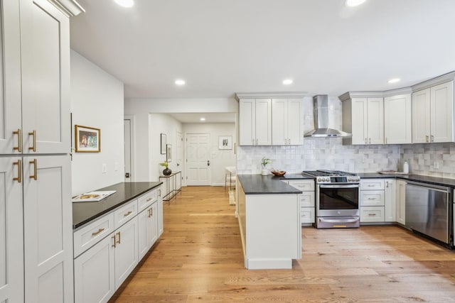527 N Columbia Ave, Bexley, OH 43209 - kitchen with wall chimney exhaust hood, appliances with stainless steel finishes, dark countertops, tasteful backsplash, and light wood finished floors