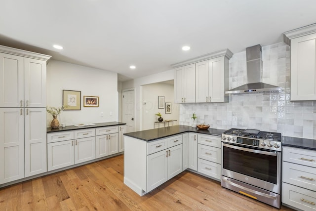 527 N Columbia Ave, Bexley, OH 43209 - kitchen with wall chimney exhaust hood, gas range, a peninsula, dark countertops, and decorative backsplash