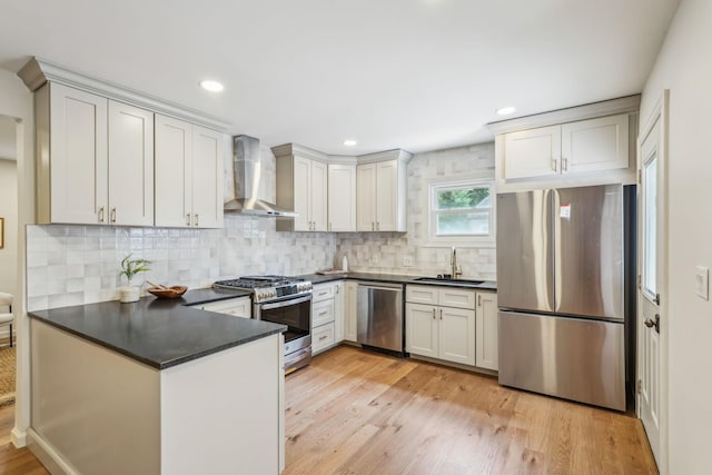 527 N Columbia Ave, Bexley, OH 43209 - kitchen featuring appliances with stainless steel finishes, wall chimney exhaust hood, dark countertops, a peninsula, and tasteful backsplash