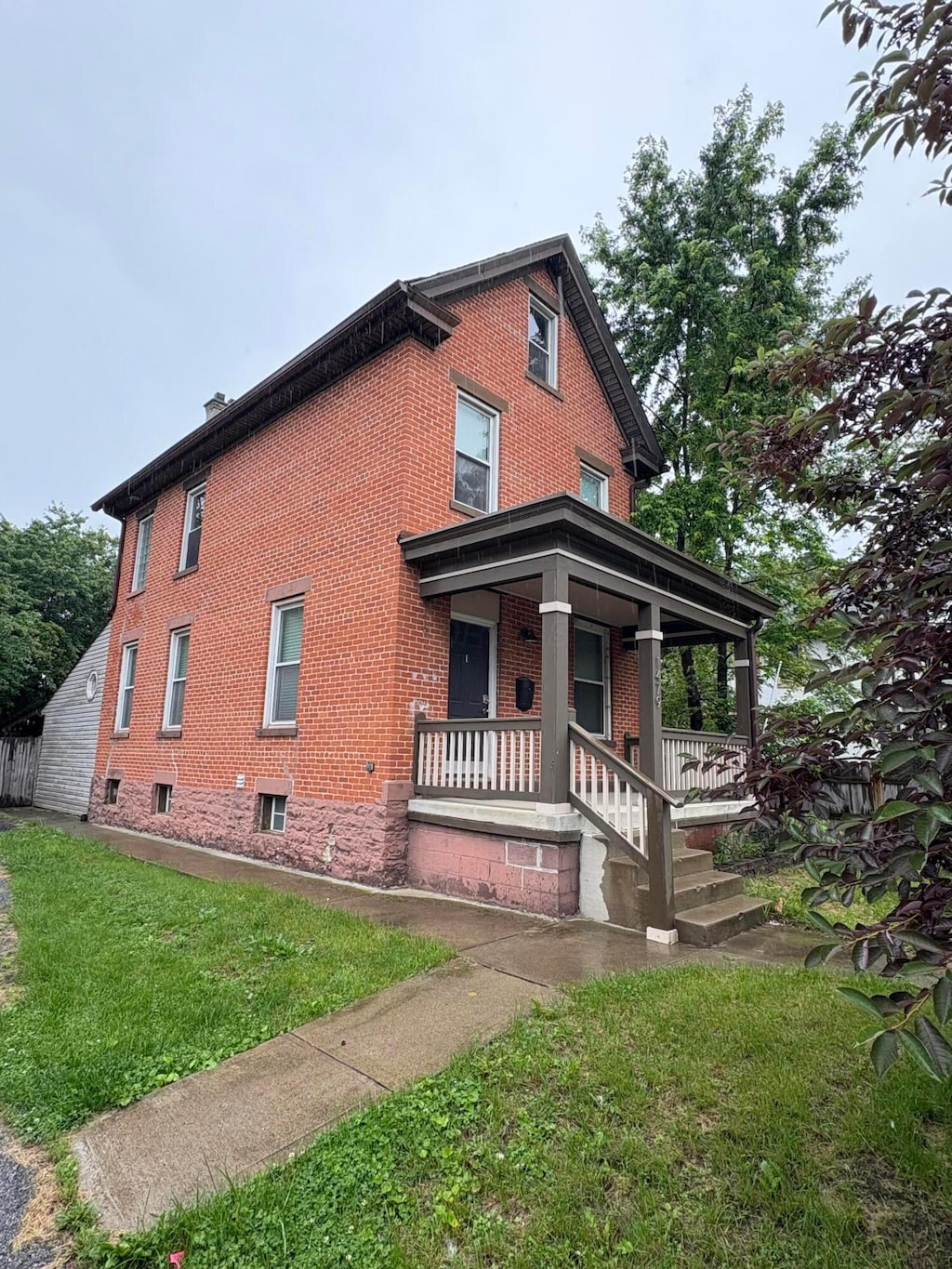 1479 Lockbourne Rd, Columbus, OH 43206 - view of side of home featuring brick siding, covered porch, and a yard