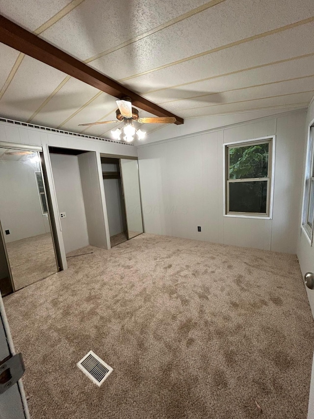 110 E Hickory Grove Rd Unit 45, Urbana, OH 43078 - unfurnished bedroom with carpet floors, beamed ceiling, multiple closets, and ceiling fan