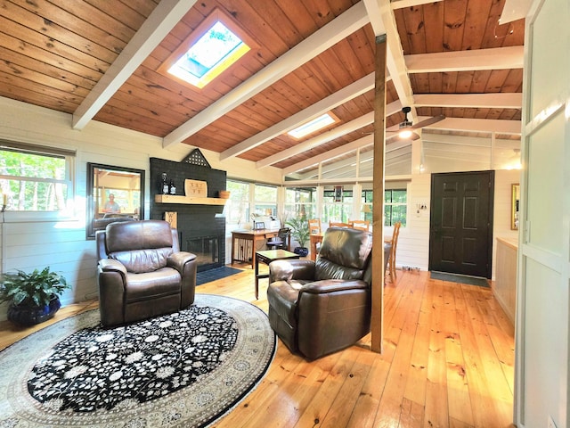 82 Lodge Ln, Hide A Way Hills, OH 43107 - living room with a fireplace with flush hearth, light wood-type flooring, a skylight, plenty of natural light, and wooden walls