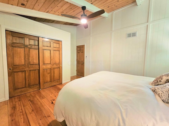82 Lodge Ln, Hide A Way Hills, OH 43107 - bedroom with light wood-style flooring, a wooden ceiling with exposed beams, ceiling fan, and wooden walls
