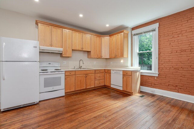 1366 S 4th St, Columbus, OH 43207 - kitchen with white appliances, under cabinet range hood, light brown cabinets, light countertops, and brick wall