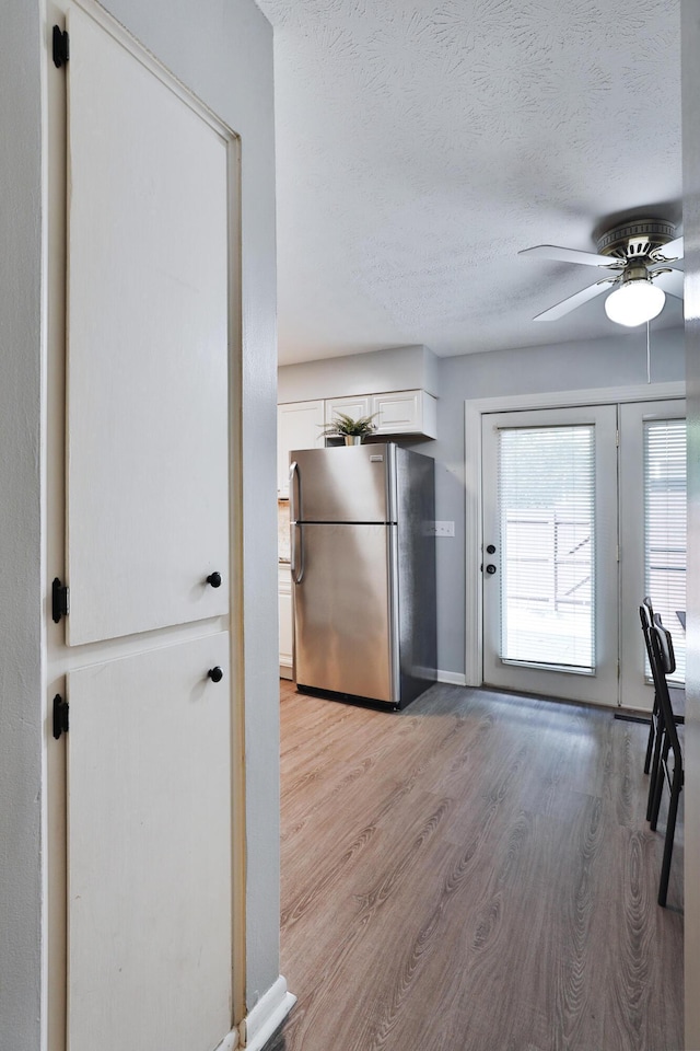 1820 Willoway Cir S, Columbus, OH 43220 - kitchen featuring freestanding refrigerator, light wood-style floors, a ceiling fan, white cabinets, and a textured ceiling