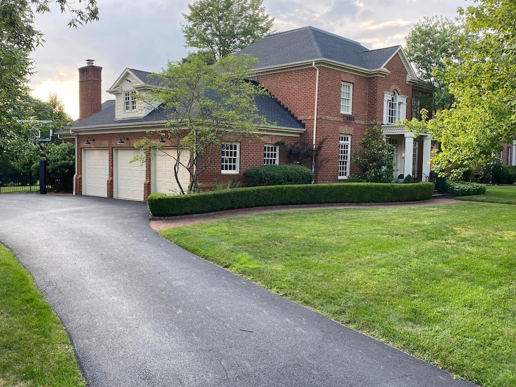 4249 Vaux Link, New Albany, OH 43054 - colonial inspired home featuring brick siding, a chimney, a front yard, driveway, and a garage