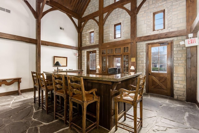 6065 Craughwell Ln, Dublin, OH 43017 - indoor bar featuring high vaulted ceiling, stone floors, and wood ceiling