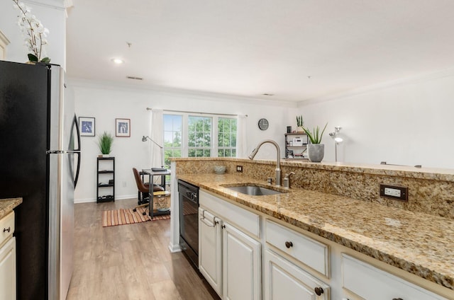 6065 Craughwell Ln, Dublin, OH 43017 - kitchen with freestanding refrigerator, black dishwasher, light wood finished floors, crown molding, and light stone countertops
