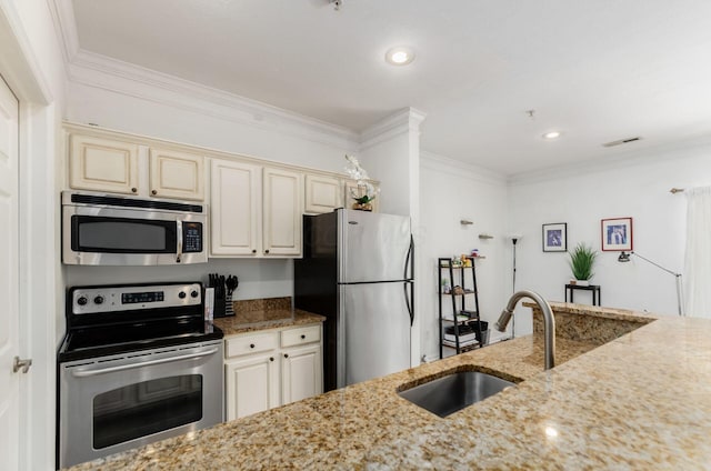 6065 Craughwell Ln, Dublin, OH 43017 - kitchen with stainless steel appliances, cream cabinetry, crown molding, light stone counters, and recessed lighting