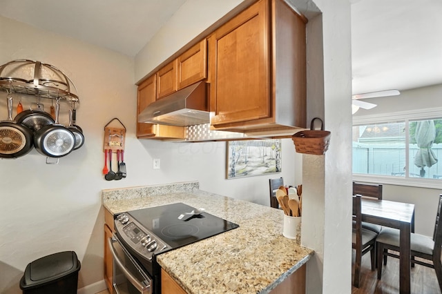 3063 Jersey Dr Unit 67, Columbus, OH 43204 - kitchen featuring electric range oven, under cabinet range hood, brown cabinets, light stone counters, and ceiling fan