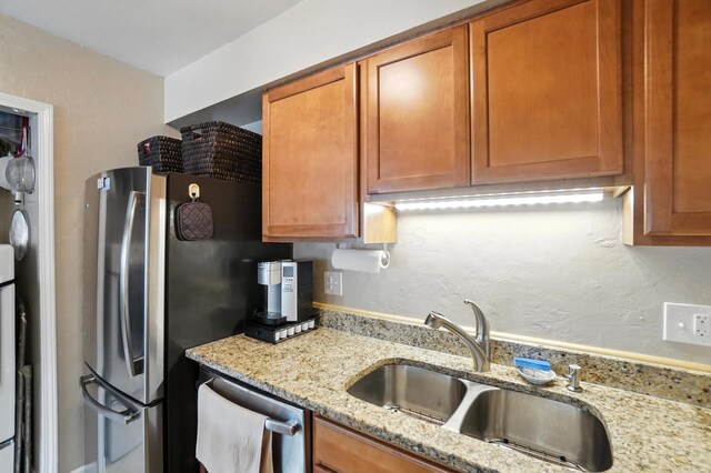 3063 Jersey Dr Unit 67, Columbus, OH 43204 - kitchen featuring appliances with stainless steel finishes, light stone countertops, brown cabinets, and a textured wall