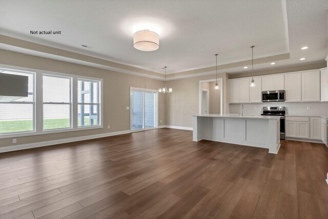 7641 Clifton Loop, Pickerington, OH 43147 - kitchen with appliances with stainless steel finishes, a tray ceiling, dark wood-style floors, tasteful backsplash, and recessed lighting