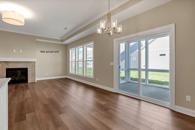 7641 Clifton Loop, Pickerington, OH 43147 - unfurnished living room featuring dark wood-style flooring, healthy amount of natural light, a chandelier, and a tile fireplace