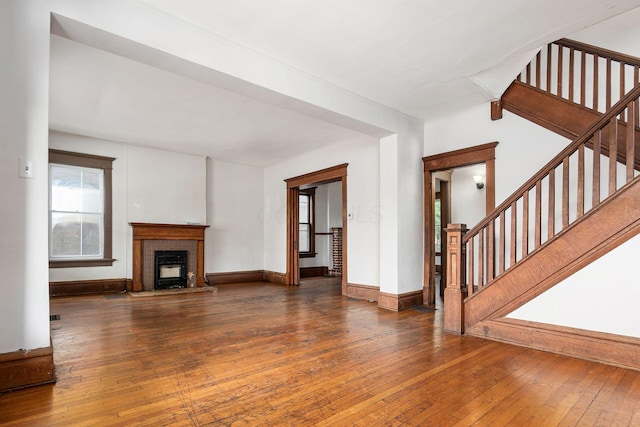356 E 20th Ave, Columbus, OH 43201 - unfurnished living room featuring stairs, hardwood / wood-style floors, and a brick fireplace