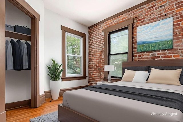 356 E 20th Ave, Columbus, OH 43201 - bedroom featuring light wood-type flooring and brick wall