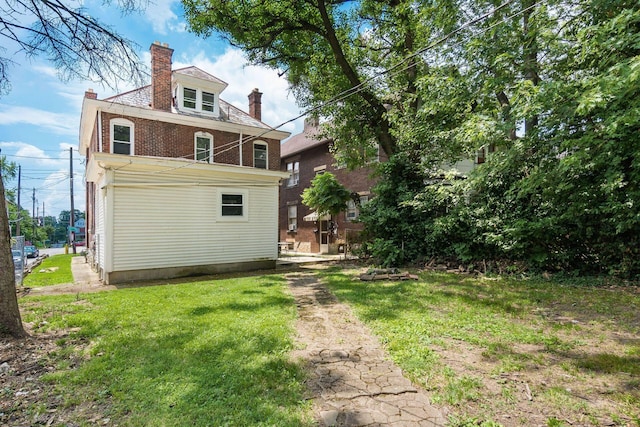 356 E 20th Ave, Columbus, OH 43201 - back of house with a chimney, a yard, and brick siding