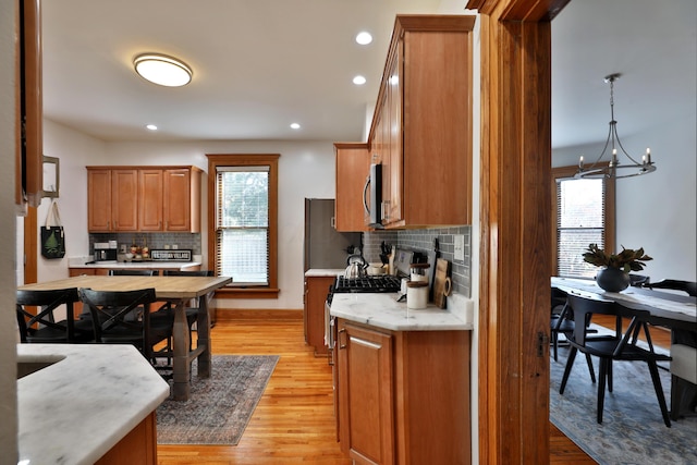 398 W 5th Ave, Columbus, OH 43201 - kitchen featuring brown cabinets, light countertops, backsplash, healthy amount of natural light, and recessed lighting