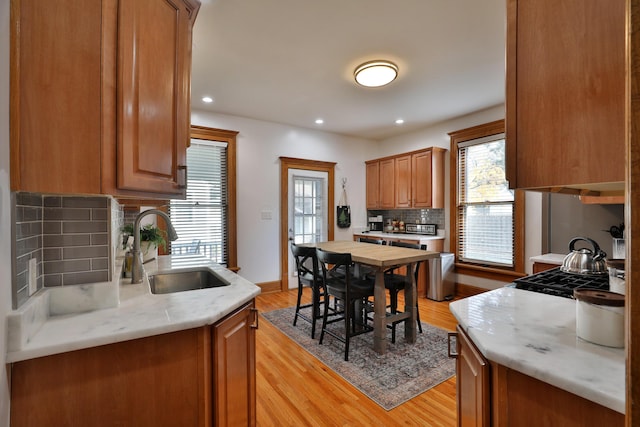 398 W 5th Ave, Columbus, OH 43201 - kitchen with light wood-style flooring, decorative backsplash, light countertops, recessed lighting, and brown cabinets