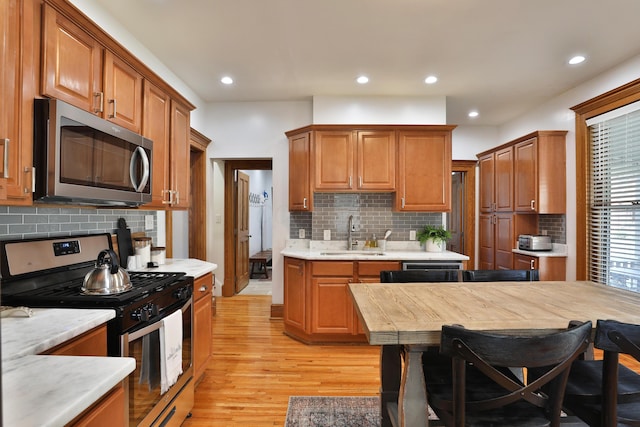 398 W 5th Ave, Columbus, OH 43201 - kitchen featuring appliances with stainless steel finishes, light countertops, light wood-type flooring, decorative backsplash, and recessed lighting