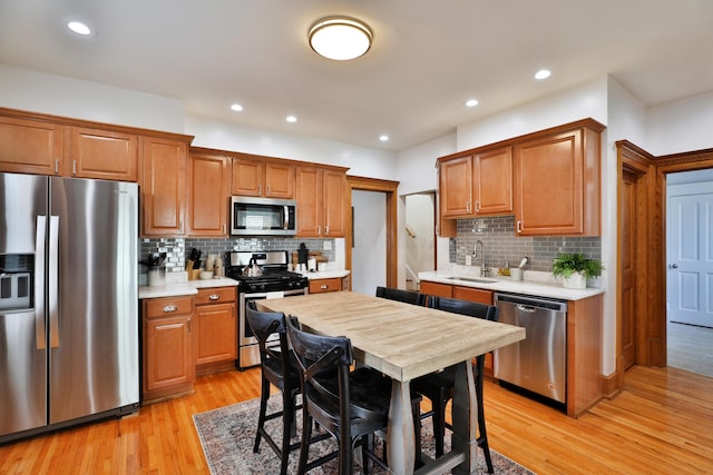 398 W 5th Ave, Columbus, OH 43201 - kitchen with stainless steel appliances, light countertops, tasteful backsplash, light wood-style flooring, and recessed lighting