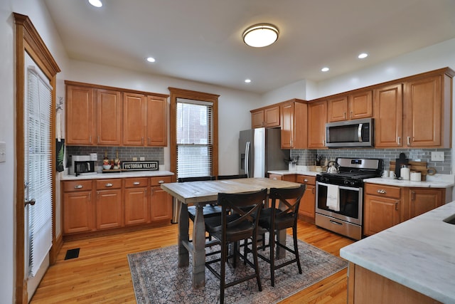 398 W 5th Ave, Columbus, OH 43201 - kitchen with stainless steel appliances, light wood finished floors, backsplash, brown cabinets, and recessed lighting