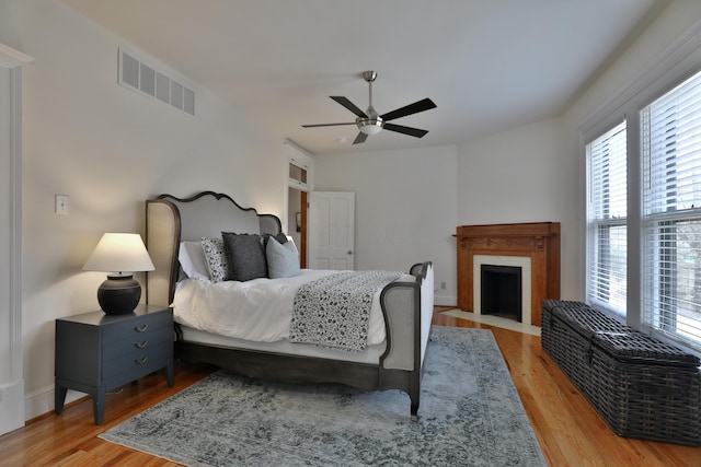 398 W 5th Ave, Columbus, OH 43201 - bedroom with multiple windows, light wood-style floors, and a fireplace with flush hearth
