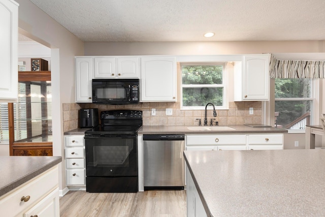 6258 Tetlin Field Dr, New Albany, OH 43054 - kitchen featuring black appliances, decorative backsplash, light wood-style flooring, a textured ceiling, and white cabinetry