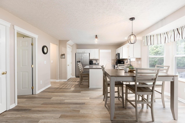 6258 Tetlin Field Dr, New Albany, OH 43054 - dining room with light wood-style flooring and a textured ceiling