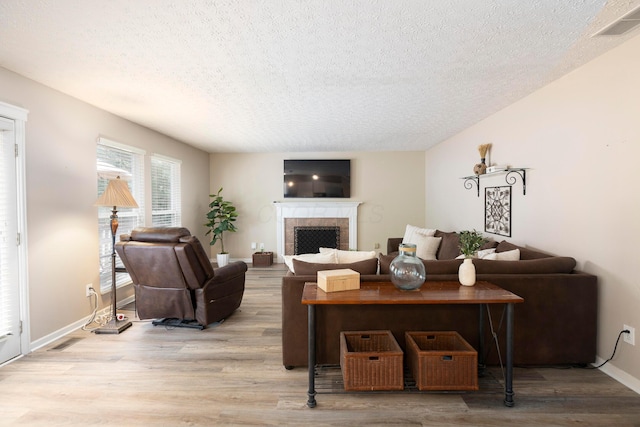 6258 Tetlin Field Dr, New Albany, OH 43054 - living area featuring a textured ceiling, wood finished floors, and a fireplace with raised hearth