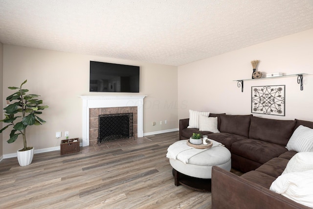 6258 Tetlin Field Dr, New Albany, OH 43054 - living area featuring light wood-style floors, a textured ceiling, and a tiled fireplace