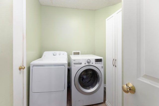 6258 Tetlin Field Dr, New Albany, OH 43054 - laundry room with washer and dryer, a textured ceiling, and cabinet space