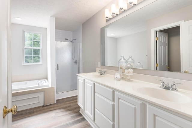 6258 Tetlin Field Dr, New Albany, OH 43054 - full bathroom featuring a shower stall, double vanity, a garden tub, wood finished floors, and a textured ceiling