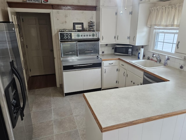 521 E Allen St, Lancaster, OH 43130 - kitchen featuring stainless steel appliances, white cabinetry, light countertops, and tasteful backsplash