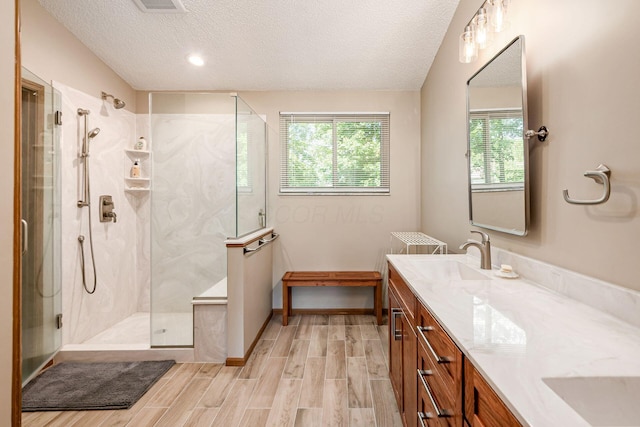4224 Eagle Head Dr, Columbus, OH 43230 - bathroom featuring a textured ceiling, vanity, a marble finish shower, and wood finished floors
