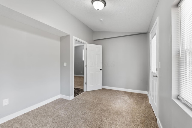 1612 Cole St, Columbus, OH 43205 - unfurnished bedroom with carpet floors, vaulted ceiling, multiple windows, and a textured ceiling