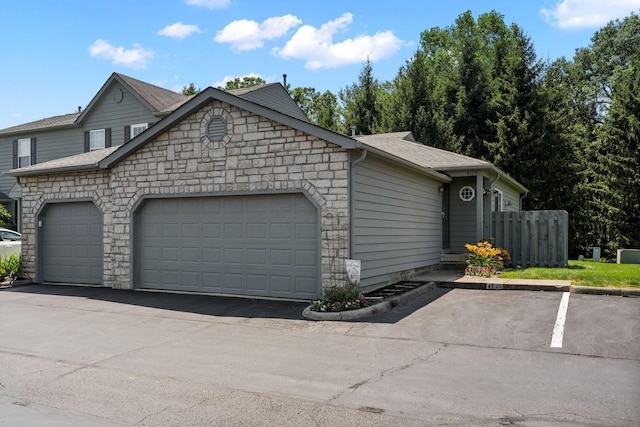 4109 Blendon Way Dr Unit 99E, Columbus, OH 43230 - view of side of property featuring stone siding and an attached garage